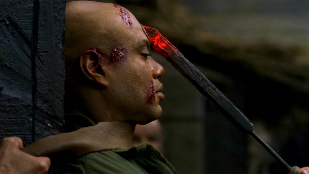 SG-1-S3-Tealc-Demons Teal'c's tattoo is seen as a mark of the Devil
